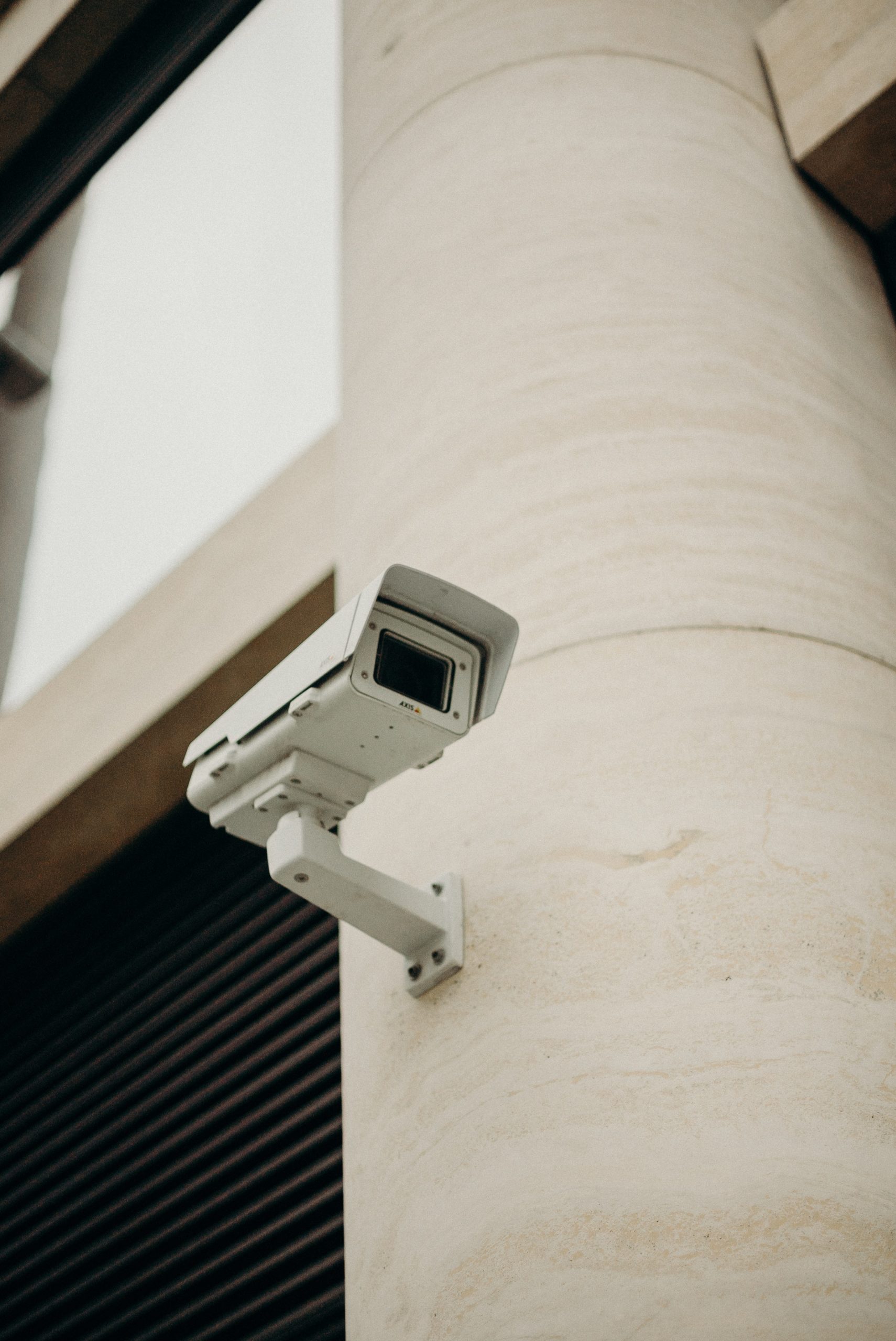 white security camera mounted on a side of a building