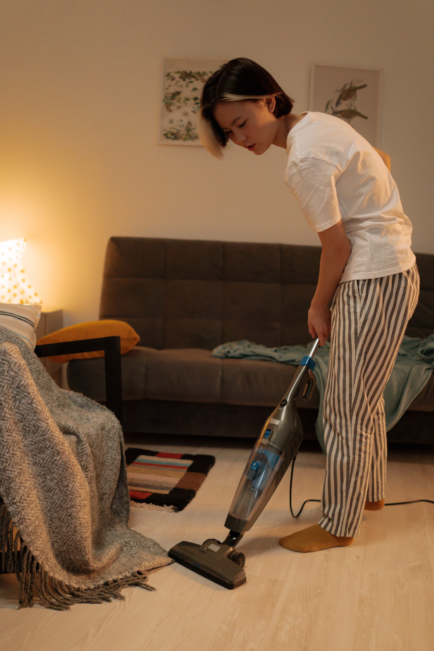 a woman cleaning the house with a vacuum, how to shop for a vacuum